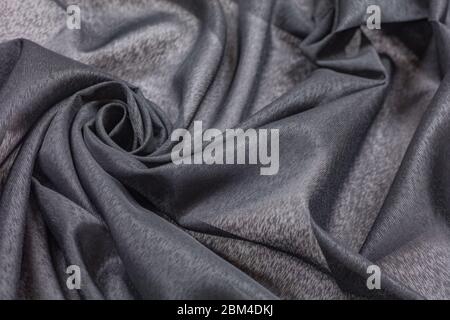 Creased black curved cloth material fragment with swirl as fabric background texture Stock Photo