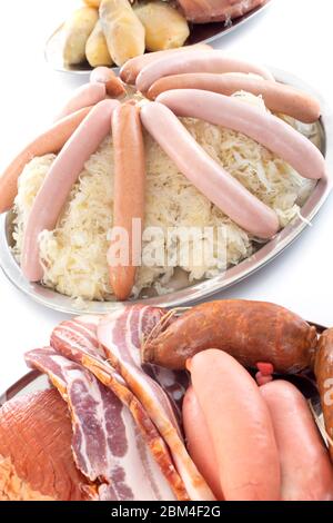 Sauerkraut and cooked meats in front of white background Stock Photo