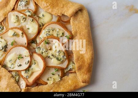 Pear galett with blue cheese, macro, savory pie, marble table, close up, copy space, top view Stock Photo