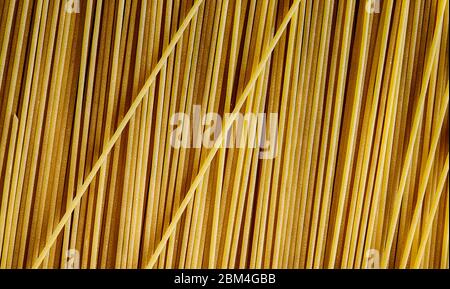 Food concept. Closeup of italian spaghetti. Uncooked spaghetti background. Flour products. Healthy food. Stock Photo