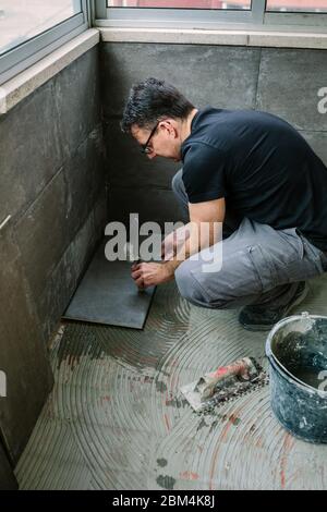 Workman laying tiles on a terrace Stock Photo