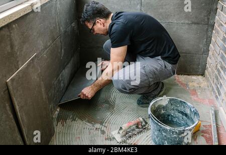 Workman laying tiles on a terrace Stock Photo