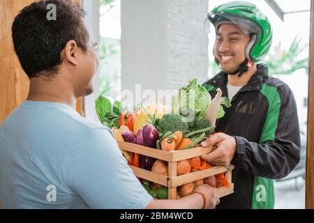 order online food courier delivering to customer at home. motorcycle delivery boy wear uniform and helmet Stock Photo