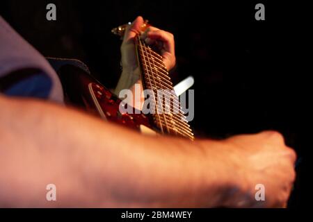 Electric guitar player, closeup photo with soft selective focus on dark Stock Photo