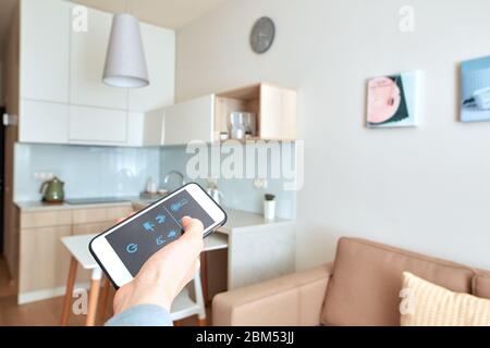 Young adult man using app for smart house on smartphone Stock Photo