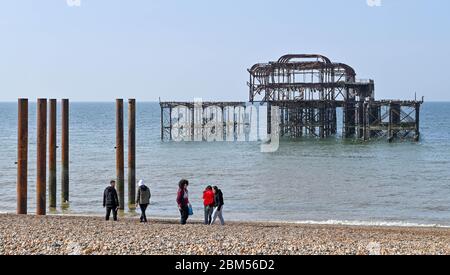 Brighton UK 7th May 2020 - A group on Brighton Beach by the West Pier on a beautiful sunny morning during the Coronavirus COVID-19 pandemic crisis . The weather is forecast to be hot and sunny over the next few days before turning cooler at the weekend . Credit: Simon Dack / Alamy Live News Stock Photo