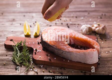 Fish Menu. Cook man plating salmon steak squeezing lemon juice. Selective Focus Stock Photo