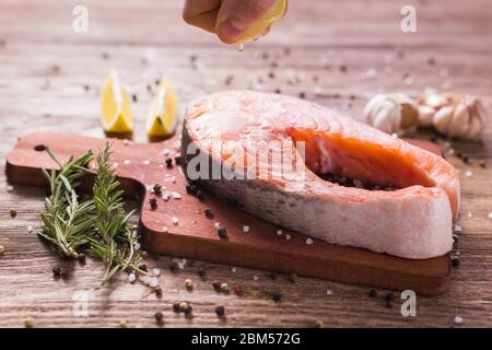 Fish Menu. Cook man plating salmon steak squeezing lemon juice. Selective Focus Stock Photo