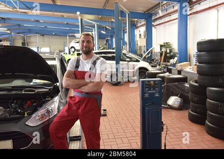 Portrait of a smiling car mechanic in a professional workshop - closeup photo Stock Photo