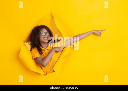 Crazy happy pointing. Cheerful african-american young woman in