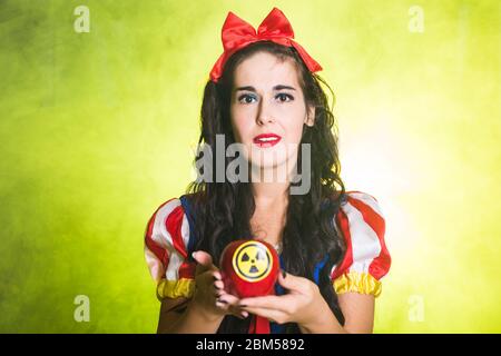 Woman holding hazardous radioactive apple. Nuclear and radiation measurement concept. Stock Photo