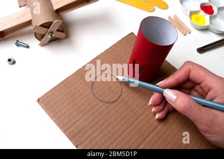 How to make airplane. Hand made toy,zero waste from toilet paper roll and popsicle sticks. For kids and parents. Step 14, draw circle for propeller Stock Photo