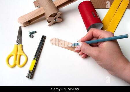 How to make airplane. Hand made toy,zero waste from toilet paper roll and popsicle sticks. For kids and parents. Step 18 measure propeller aircraft. Stock Photo