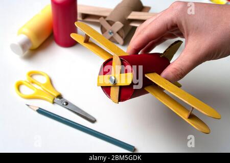 How to make airplane. Hand made toy,zero waste from toilet paper roll and popsicle sticks. For kids and parents. Step 21 put all details of aircraft Stock Photo