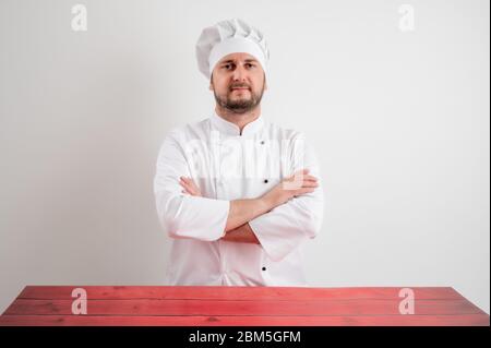 Young male chef in white uniform looking confident posing on a white isolated background Stock Photo