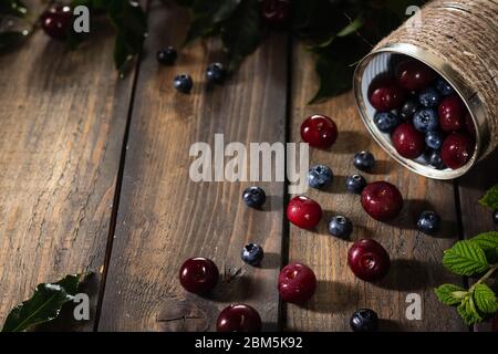 Berries in a can on a wooden background. Stock Photo
