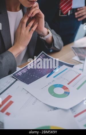 Cropped view of data analysts working with charts on table Stock Photo