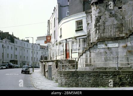 Bristol in the 60s and 70s:  The south-west end of Royal York Crescent in Clifton in June 1970, looking up past Courage’s Portcullis pub towards the Princes Buildings on Sion Hill, before parking pressures and controlled parking zones.  The area was popular with Bristol University students in those pre-central heating days with many buildings split into flats and rented out on yearly lets. Stock Photo
