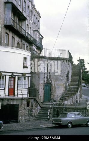 Bristol in the 60s and 70s:  The south-west end of Royal York Crescent, a listed late Georgian terrace in Clifton, next to the corner of the Portcullis pub on Sion Hill in July 1970.  The area was popular with Bristol University students in those pre-central heating days with many buildings split into flats and rented out on yearly lets, including some of the more dilapidated buildings in the Crescent, where several balconies were in poor repair. Stock Photo