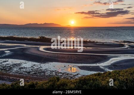 Arran sunset from beach at Greenan Castle, Heads of Ayr. Stock Photo