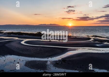 Arran sunset from beach at Greenan Castle, Heads of Ayr. Stock Photo