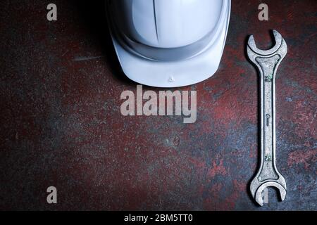 old wrench on old red rusty floor Top view with space for text. Plumber tools. Repair man equipment. Construction worker. Stock Photo