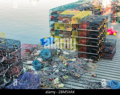 Many lobster traps stacked on a pier with rope and bouys ready to be put to work. Stock Photo