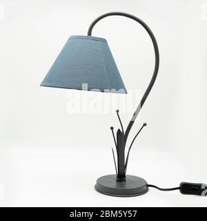 A modern table lamp with a blue lampshade and a metal base, cut out on white background Stock Photo