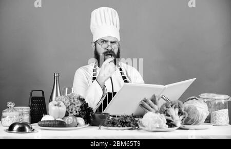 Bearded man cook in kitchen, culinary. Healthy food cooking. Dieting and organic food, vitamin. We detest vegetables. Vegetarian. Mature chef with beard. Chef man in hat. Secret taste recipe. Stock Photo