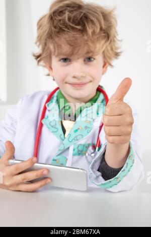 busy young doctor shows thumbs up, a symbol of good luck Stock Photo