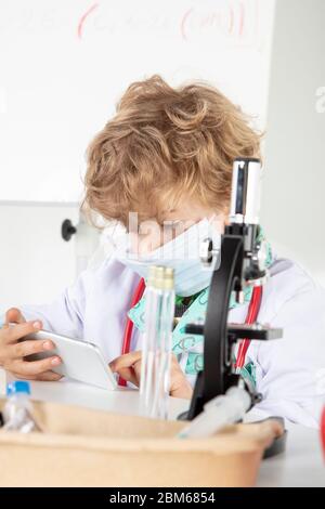 young doctor sitting over a microscope in his laboratory Stock Photo