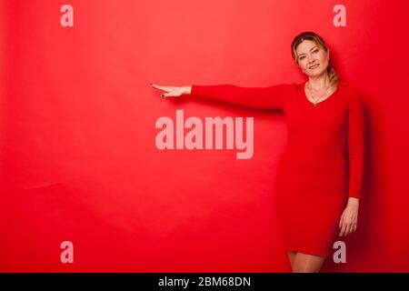 Beautiful woman in a red dress on the background for inscriptions Stock Photo