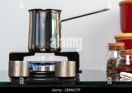 Brew coffee in a steel turk on a gas stove Stock Photo
