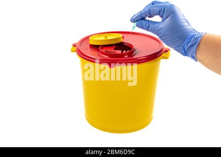 Closeup of hand depositing a used lancet on waste needle container. Health worker throws sharp waste into the medical waste bin. Medical Waste Rubbish Stock Photo