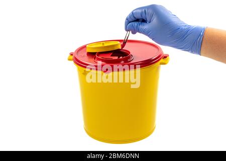 Closeup of hand depositing a used lancet on waste needle container. Health worker throws sharp waste into the medical waste bin. Medical Waste Rubbish Stock Photo