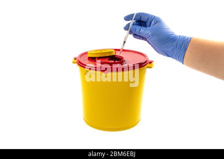 Closeup of hand depositing a used lancet on waste needle container. Health worker throws sharp waste into the medical waste bin. Medical Waste Rubbish Stock Photo