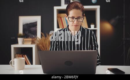 Serious woman working from home Stock Photo