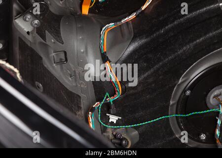 Large wide cable with multicolored orange and green wires, connectors and terminals in the wiring repair shop and electricians for connecting and tran Stock Photo