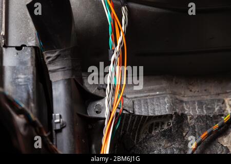 Large wide cable with multicolored orange and green wires, connectors and terminals in the wiring repair shop and electricians for connecting and tran Stock Photo