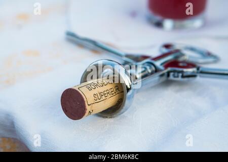 Natural cork stopper in a winged corkscrew from opening a bottle of  French Bordeaux Superieur red wine at an alfresco picnic in Kent, UK Stock Photo