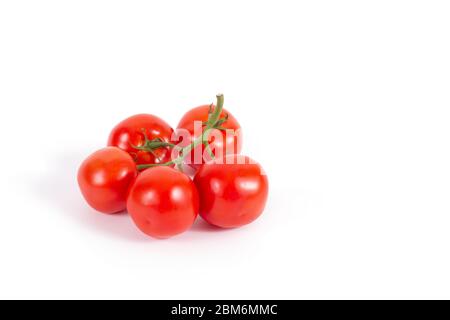 Fresh tomatoes on branch isolated on white. Branch of delicious five tomatoes on the left. Stock photo, side view. Ingredients for cooking. Healthy Stock Photo
