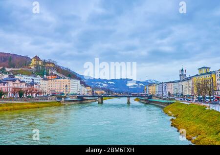 SALZBURG, AUSTRIA - MARCH 1, 2019: The cityscape of old town with fast flowing Salzach river in rainy day, on March 1 in Salzburg Stock Photo