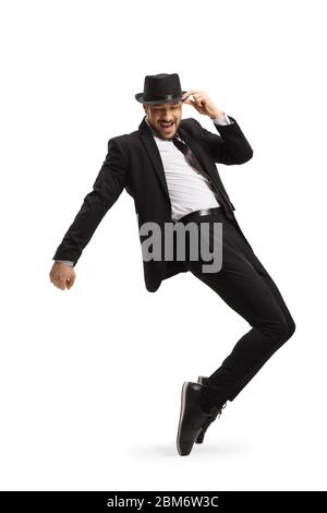 Man in a suit and hat dancing and standing on tiptoes isolated on white background Stock Photo