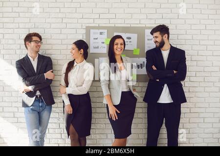 Group of young happy business people team standing teamwork are talking on the background. Concept meeting businessmen business women analytics startu Stock Photo