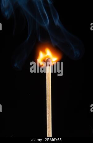 A burning matchstick on black background Stock Photo