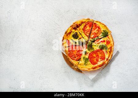 Traditional vegetable quiche with broccoli sliced on light surface. Food flat lay Stock Photo