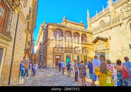 GRANADA, SPAIN - SEPTEMBER 27, 2019: The queue of tourists at the Gothic sandstone building of Capilla Real (Royal Chapel), decorated with carved garl