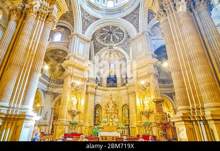 GRANADA, SPAIN - SEPTEMBER 27, 2019: Impressive Baroque interior of Sagrario (Sacred Heart) church with massive columns, sculptures, carved dome with