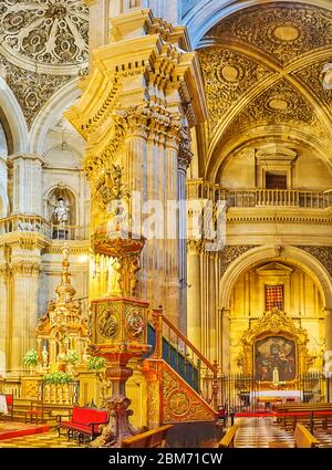 GRANADA, SPAIN - SEPTEMBER 27, 2019: The masterpiece wooden pulpit of Sagrario (Sacred Heart) church, decorated with carved sculptures, relief ornamen