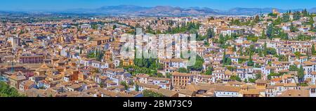 Enjoy panoramic view of old Granada from Alhambra walls, overlooking historical neighborhoods, dense buildings and Sierra Nevada mountains on the back Stock Photo